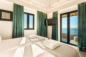 a bedroom with a white bed with a view of the ocean at Mani Theasis in Stoupa