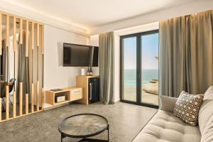 a living room with a couch and a view of the ocean at Mani Theasis in Stoupa