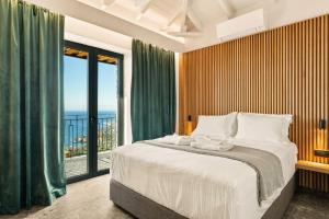 a bedroom with a bed and a large window at Mani Theasis in Stoupa