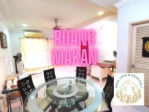 a dining room with a glass table and a pink sign at Ames Leng I-City Home Sweet Home in Shah Alam