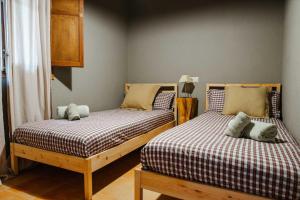 two beds sitting next to each other in a room at LAS GLICINIAS casa rural en el campo in Tordera