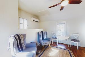 a living room with a ceiling fan and a chair and a sink at The Pink House on Main - Upper in Eureka Springs