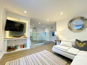 uma sala de estar com um sofá branco e um espelho em Stunning Loft Apartment South Queensferry High St Bridge Views! em Queensferry