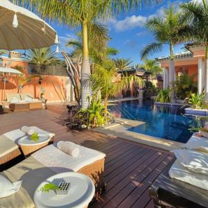 a backyard with a swimming pool and a house with a resort at Royal Garden Villas, Luxury Hotel in Adeje