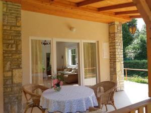 eine Terrasse mit einem Tisch und Stühlen auf einer Veranda in der Unterkunft Schieszl Apartments Zamárdi 4 in Zamárdi