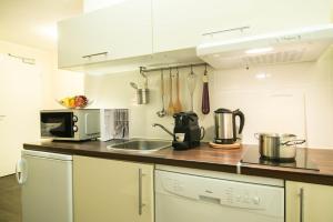 a kitchen with a stove top oven and a microwave at BATU Apart Hotel in Munich
