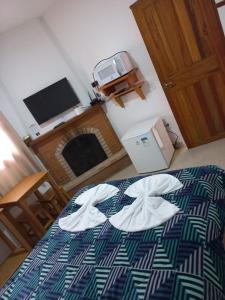 a bedroom with a bed with a blanket with a flower on it at Chalés lima in Monte Verde