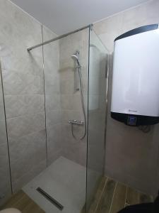 cabina de ducha con puerta de cristal y ducha en Apartament Tzar Kaloyan, en Burgas