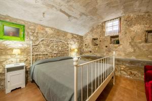 1 dormitorio con cama y pared de piedra en Can Cirera, casa rural, en Serinyà