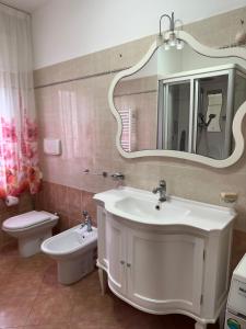 a bathroom with a sink and a toilet and a mirror at Appartamenti Estivi in Cirò Marina