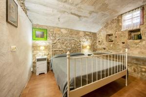 a bedroom with a bed and a stone wall at Casa rural ideal para familias y amigos in Serinyà