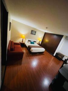 ein Hotelzimmer mit einem Bett und einem Sofa in der Unterkunft Hotel La Sabana in Bogotá