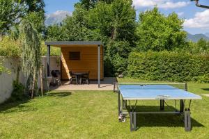a ping pong table in a yard with a shed at Private green getaway in Bled
