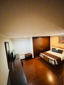 a bedroom with a large bed and a wooden floor at Hotel La Sabana in Bogotá