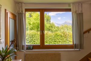 a window with a view of a mountain at Private green getaway in Bled
