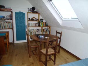 a room with a table and chairs and a book shelf at Chambres d'hôtes de Kermerrien in Porspoder