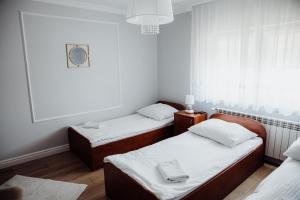 a room with two beds and a window at Pokoje gościnne Biała Dama in Mławka
