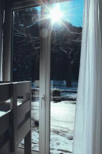 una ventana con el sol brillando a través de la nieve en Eau Berges - Chez Mamie, en Vicdessos