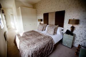 a bedroom with a large bed and a night stand at Chelmsford Serviced Apartments in Chelmsford