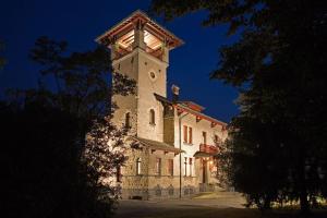 um grande edifício com uma torre de relógio à noite em Albergo Villa & Roma em Palazzolo sullʼOglio