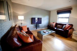 a living room with two couches and a tv at Chelmsford Serviced Apartments in Chelmsford