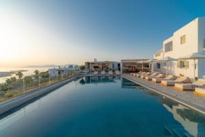 a large swimming pool with a view of the ocean at Sonia in Mikonos