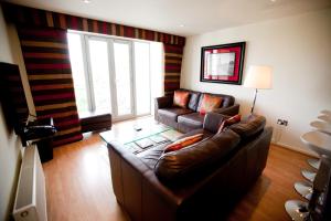 a living room with a couch and a large window at Chelmsford Serviced Apartments in Chelmsford