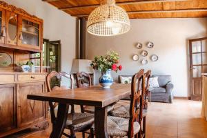 un tavolo da pranzo con sedie e un vaso con fiori di Las HORTENSIAS casa rural en el campo a Tordera