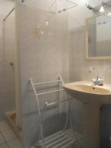 ein Bad mit einem Waschbecken, einer Dusche und einem Waschbecken in der Unterkunft L'embarcadère in Mimizan-Plage