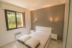 ein Schlafzimmer mit einem weißen Bett und einem Fenster in der Unterkunft L'embarcadère in Mimizan-Plage