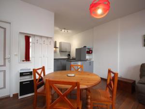 eine Küche und ein Esszimmer mit einem Holztisch und Stühlen in der Unterkunft Mont-Dore : Beau T2 avec WIFI en centre, proche Thermes - FR-1-608-163 in Le Mont-Dore