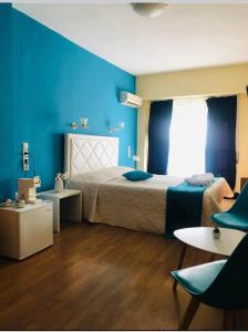 1 dormitorio con cama y pared azul en Hotel Rodini, en Kato Rodini