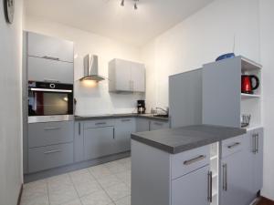 eine große weiße Küche mit weißen Schränken und Geräten in der Unterkunft Mont-Dore : Beau T2 avec WIFI en centre, proche Thermes - FR-1-608-163 in Le Mont-Dore