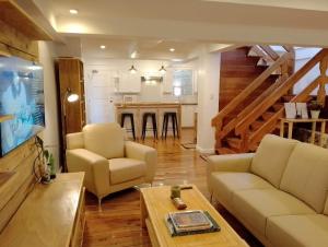 a living room with a couch and chairs and a kitchen at The White Pine at No 7 Pucay Village in Baguio