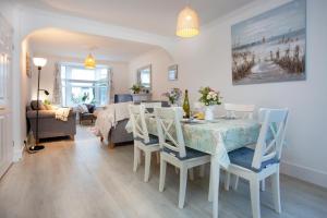 ein Esszimmer und ein Wohnzimmer mit Tisch und Stühlen in der Unterkunft Rose Cottage in Sidmouth