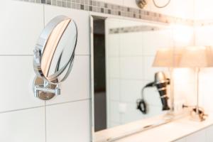 un espejo en el armario del baño junto a un lavabo en Appartementhaus am Schloss, en Weimar