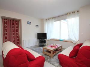 ein Wohnzimmer mit zwei roten Sofas und einem TV in der Unterkunft Grand T3 au Mont-Dore avec Terrasse, Parking et WiFi, à 200m du Centre - FR-1-608-177 in Le Mont-Dore