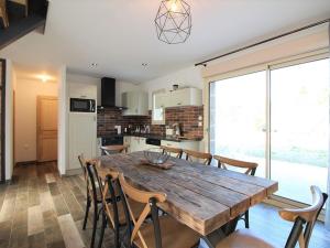 a kitchen and dining room with a wooden table and chairs at Maison La Bourboule, 3 pièces, 8 personnes - FR-1-608-203 in La Bourboule