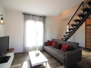 ein Wohnzimmer mit einer Couch und einer Treppe in der Unterkunft Maison récente 70m² | 8 pers | 3 chambres | Terrasse | Parking | La Bourboule - FR-1-608-203 in La Bourboule + 5 Fotos