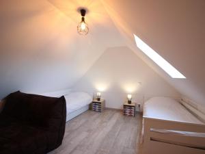 a attic bedroom with two beds and a chair at Maison La Bourboule, 3 pièces, 8 personnes - FR-1-608-203 in La Bourboule