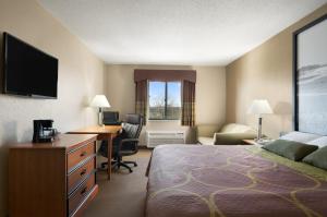 a hotel room with a bed and a desk and a computer at Super 8 by Wyndham Green Bay I-43 Bus. Park in Green Bay