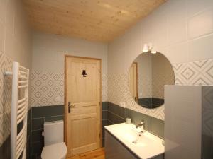 a bathroom with a sink and a toilet and a mirror at Le Mont-Dore: Splendide Chalet 5 Chambres avec Terrasse, Garage Double, et WiFi - FR-1-608-188 in Le Mont-Dore +15 photos