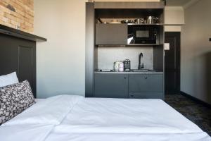 a bedroom with a white bed and a kitchen at Numa Prague Root in Prague