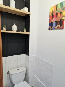 a bathroom with a white toilet and a shelf at Maison Richelieu in Bram