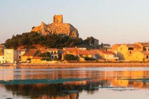 a town with a castle on a hill next to the water at Maison Richelieu in Bram