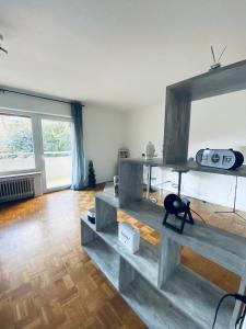 a living room with wooden floors and a large window at Zentral gelegenes Apartment - DSL, Küche, Balkon, Parkplatz in Lüdenscheid