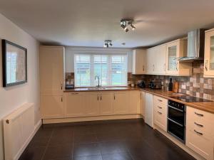 a kitchen with white cabinets and a sink at Grange Farm in Lincolnshire