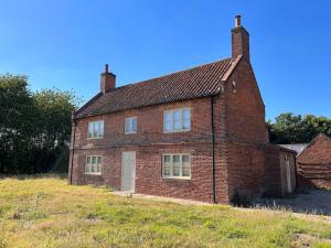 an old brick house on a hill in a field at Grange Farm in Lincolnshire