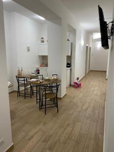Il comprend un salon avec des tables et des chaises ainsi qu'une cuisine. dans l'établissement G&G Home, à Cosenza