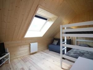 Cette petite chambre comprend des lits superposés et une fenêtre. dans l'établissement Chalet moderne 92m² avec garage, bornes de recharge, Wi-Fi, proche du centre - FR-1-608-206, à Le Mont-Dore